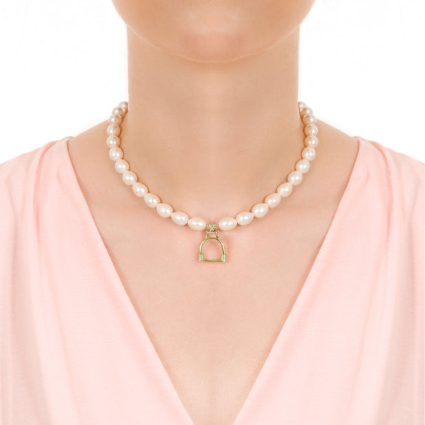 Close up shot of model wearing Designer solid 9ct gold vintage stirrup and cultured pearl necklace on white background