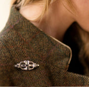 model wearing tweed and designer solid silver stirrup and strap brooch/stockpin