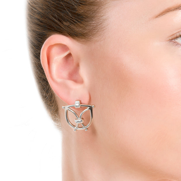 close up image of model wearing olid silver designer wrought iron inspired earrings on white background.