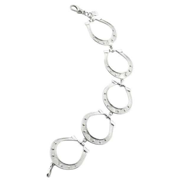 Designer solid silver large horseshoe bracelet on white background.