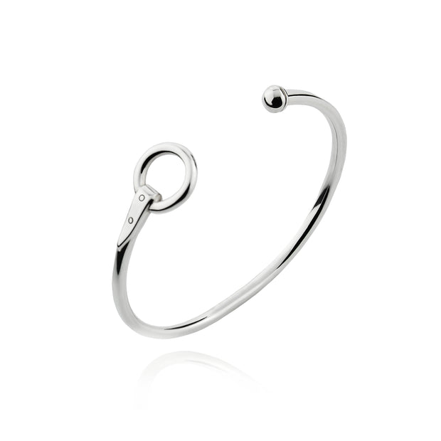Designer solid silver torque style equestrian styled bangle on white background.