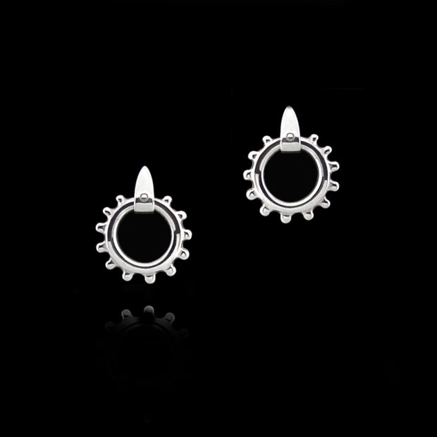designer solid silver equestrian swivel earrings on black background.