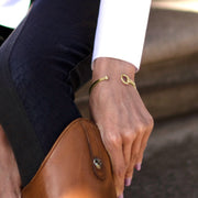 Model wearing Designer solid 9ct yellow gold torque style equestrian styled bangle. 