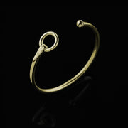 Designer solid 9ct yellow gold torque style equestrian styled bangle on black background.