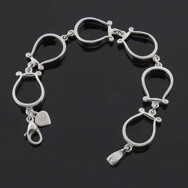 Designer six western stirrup solid silver bracelet on black background.