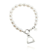 designer silver and cultured pearl bracelet with vintage stirrup charm on white background