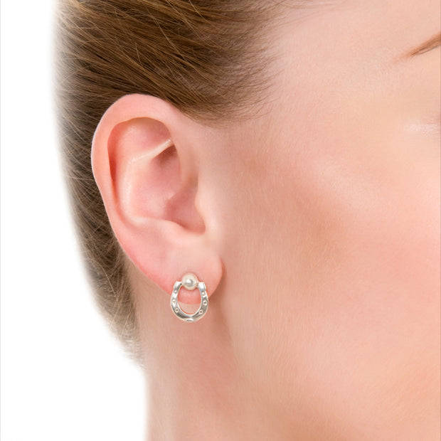 close up image of model wearing designer silver horseshoe stud earrings