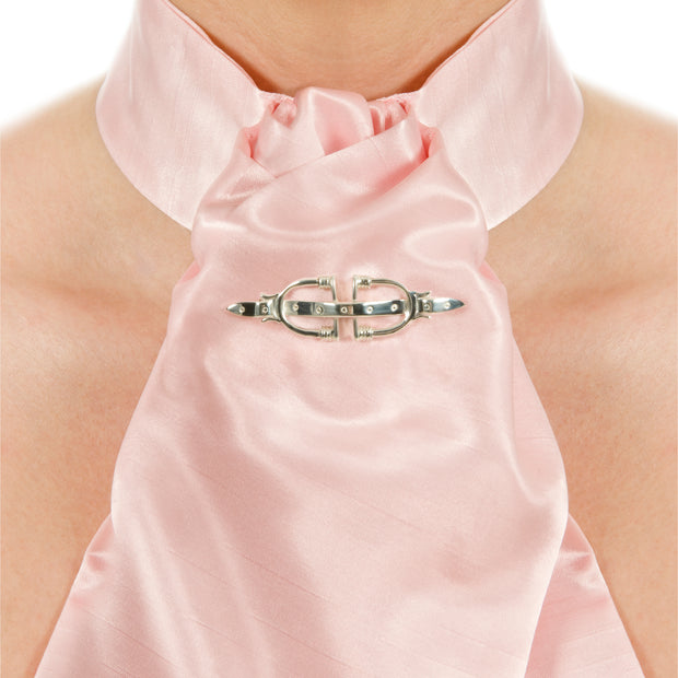 neck shot of model wearing pink silk stock and designer solid silver stirrup and strap brooch/stockpin