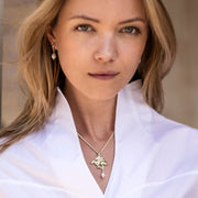 model wearing gold carved hare with pearl drop Designer necklace