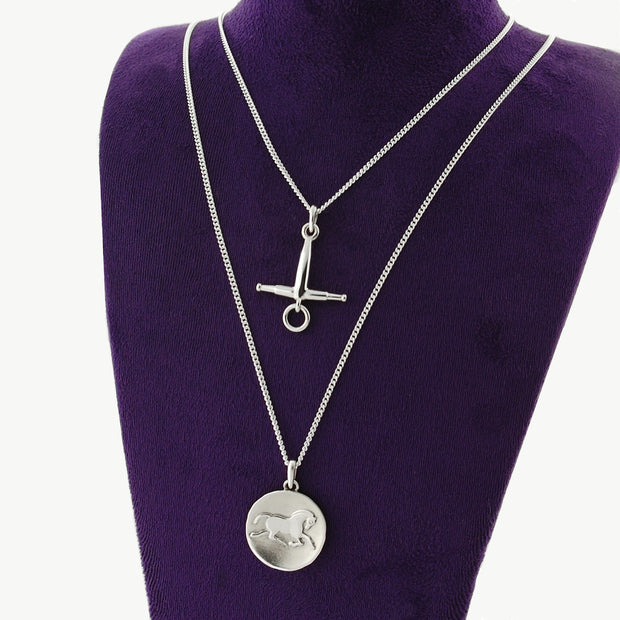 Designer solid silver |fulmer horse bit necklace and Horse coin necklace on purple display bust.