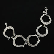 Designer solid silver large horseshoe bracelet on black background.
