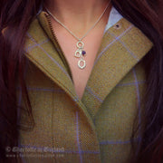 Charlotte wearing Designer solid silver horseshoe, stirrup and amethyst charm necklace with tweed.