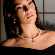 Model wearing Designer solid 9ct gold vintage stirrup and cultured pearl necklace.