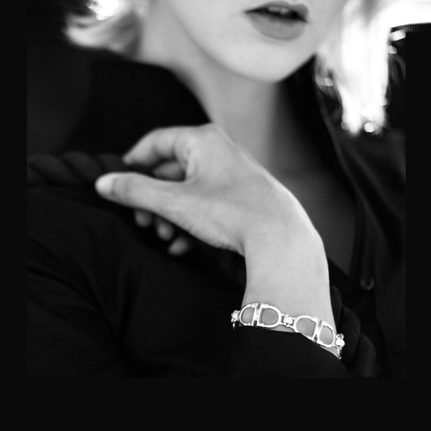 model wearing designer solid silver stirrup and leather strap bracelet Black and white image