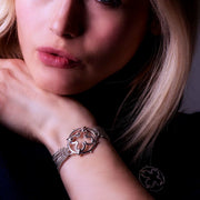 model wearing designer multistrand silver chain bracelet with wrought ironwork inspired central motif