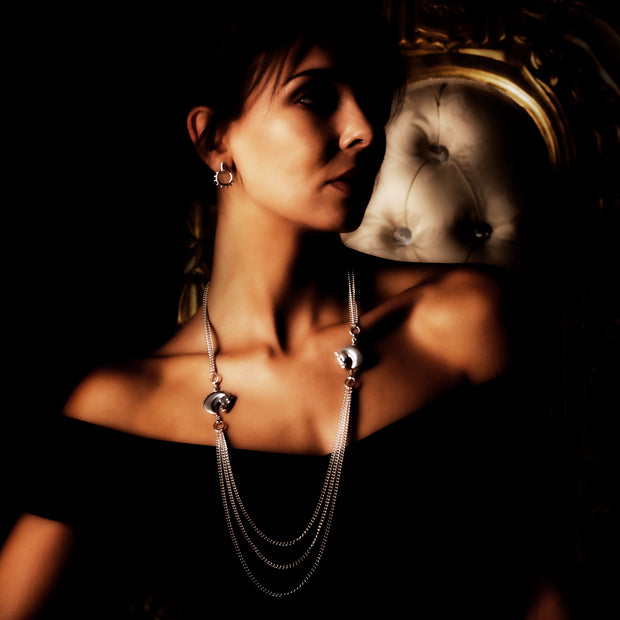 model wearing designer silver double horsehead and triple chain neckpiece