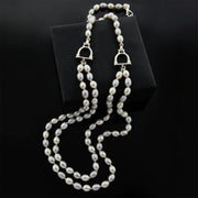 designer double strand of grey and cream pearl with stirrup detail necklace on black background