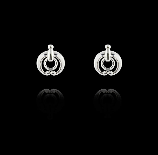 designer silver equestrian stud earrings on black background