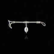 designer solid silver hunting crop stockpin brooch with cultured pearl drop on black background.