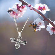 designer silver carved honey bee necklace on apple blossom background