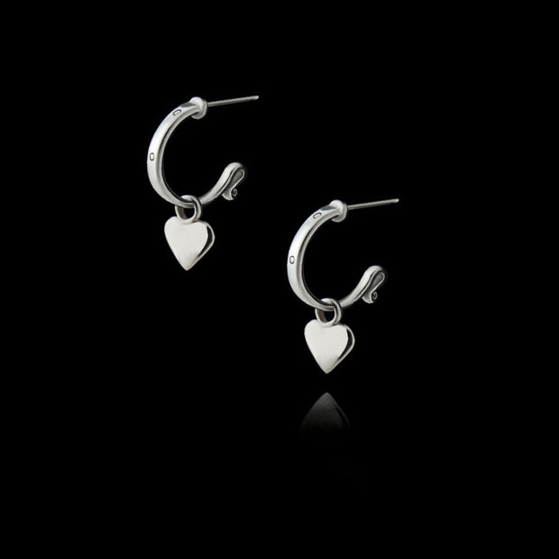 designer solid silver leather strap hoops with removable heart drop earrings on black background.