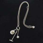 Designer Solid silver and cultured pearl polo necklace with mallet helmet and ball on black background.