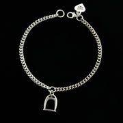 designer  solid silver stirrup and chain bracelet on black  background.