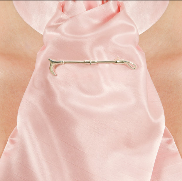 neck shot of model wearing designer solid silver crop stockpin brooch on white background.