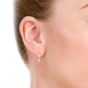 earshot of model wearing designer solid silver leather strap hoop earrings on white background