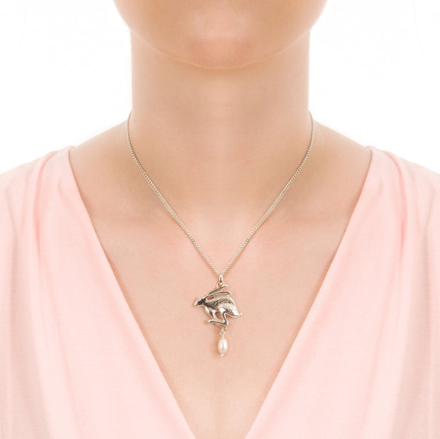 designer carved silver hare with pearl drop on model's neck