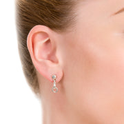 close up shot of model wearing designer solid silver windsor horsebit drop earrings on white background