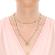 Close up of model wearing designer solid silver link and curb chain necklace with silver leather strap details and ring and toggle catch.